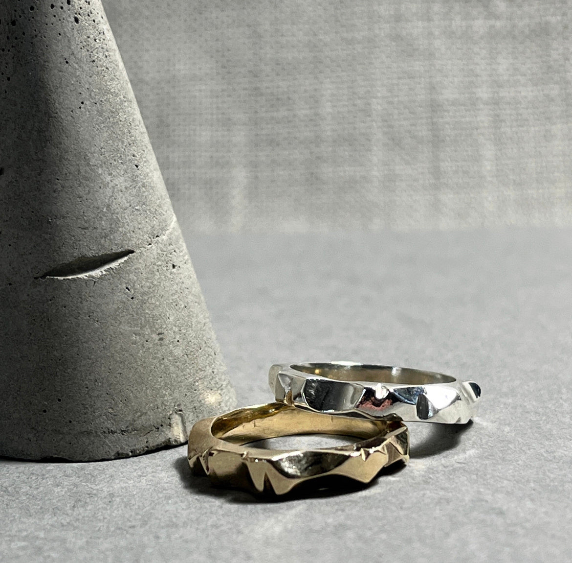 Two custom made rings, one gold and one silver, both shaped in an organic way